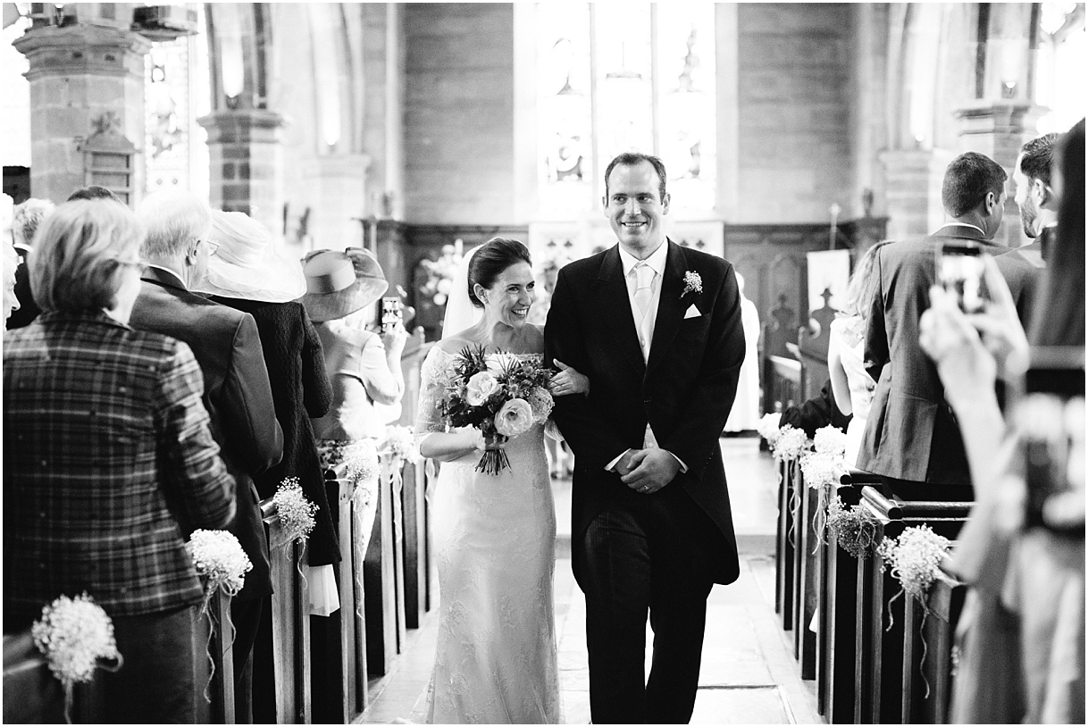 Bride and groom walking down aisle in church 