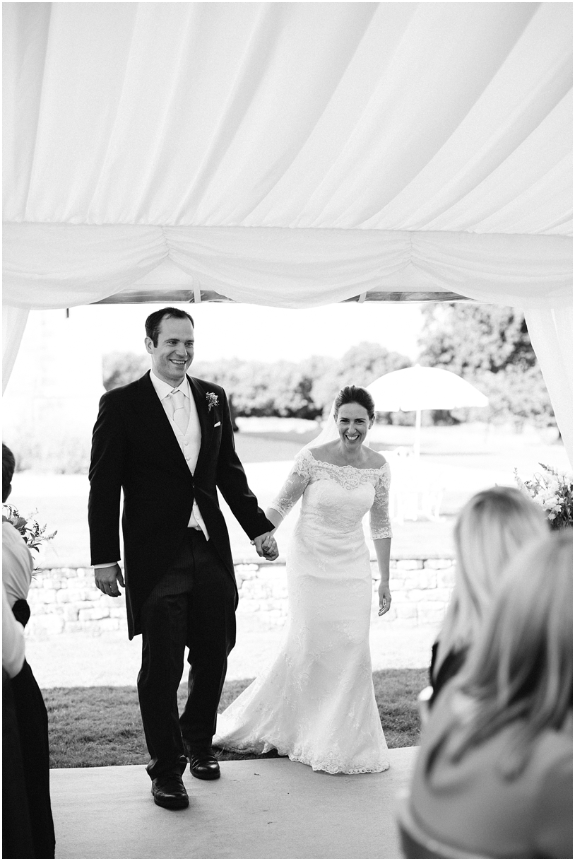 Bride and groom walking into marquee at Chiddingstone Castle