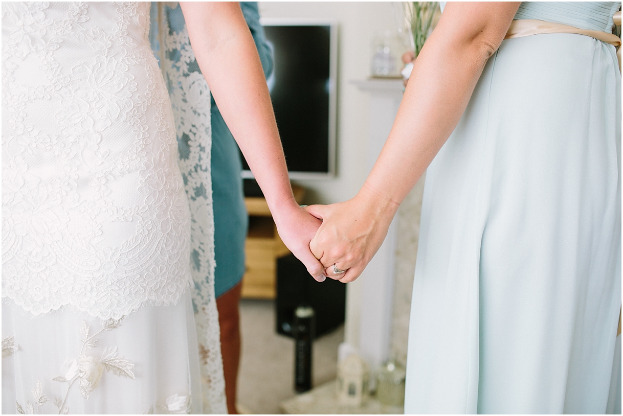 Bride holding hands with bridesmaid