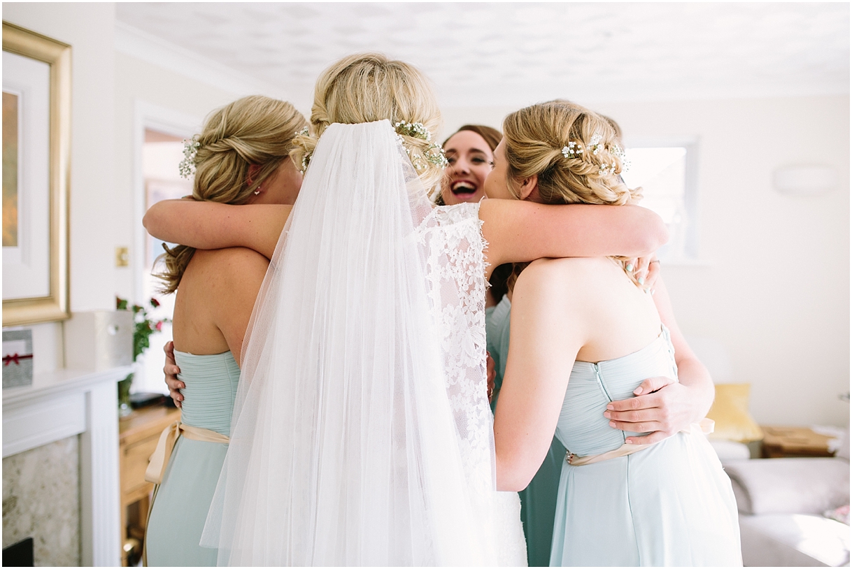 Bride hugging bridesmaids