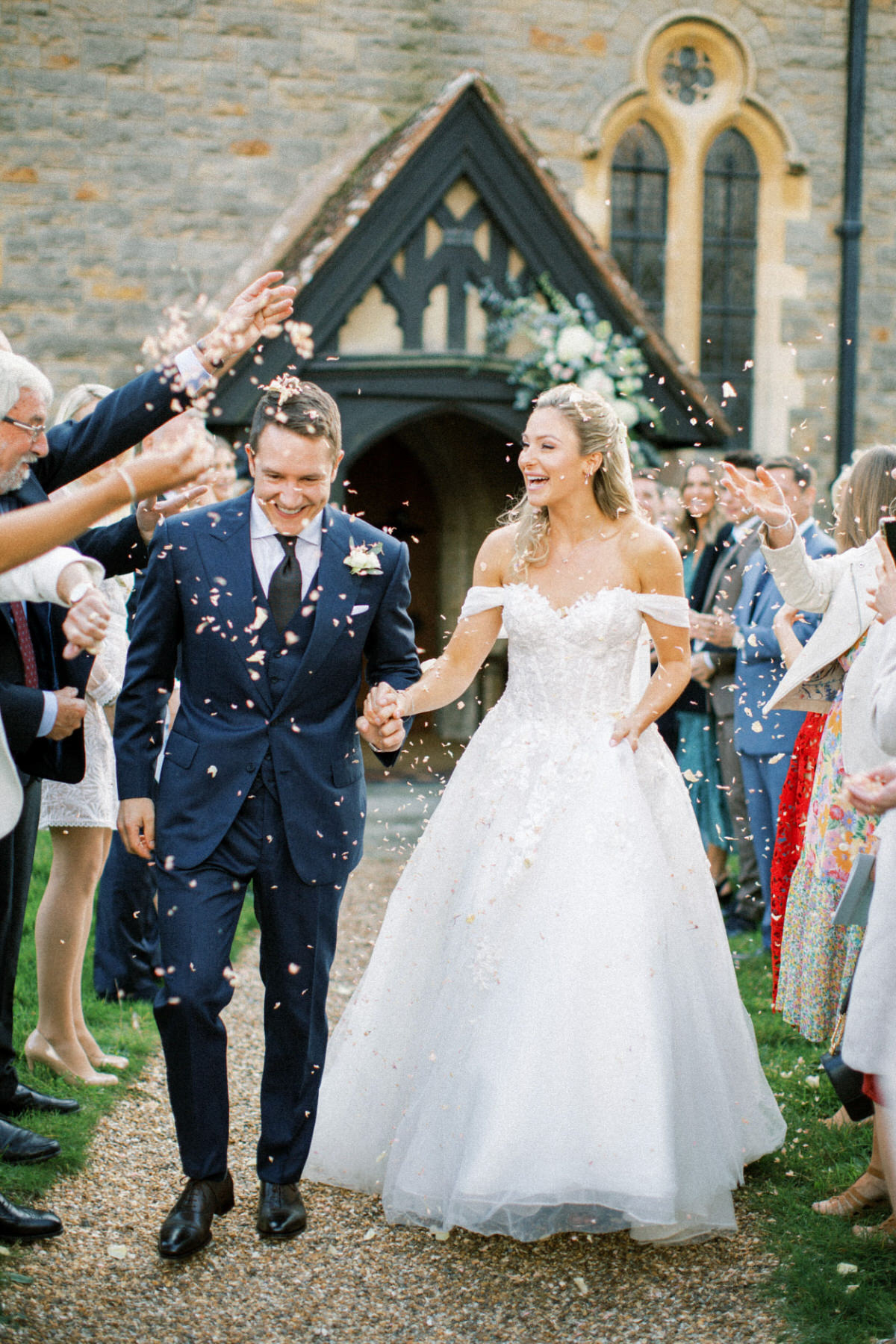 luxury wedding photographer Camilla Arnhold photographs Bride and groom walking through confetti 